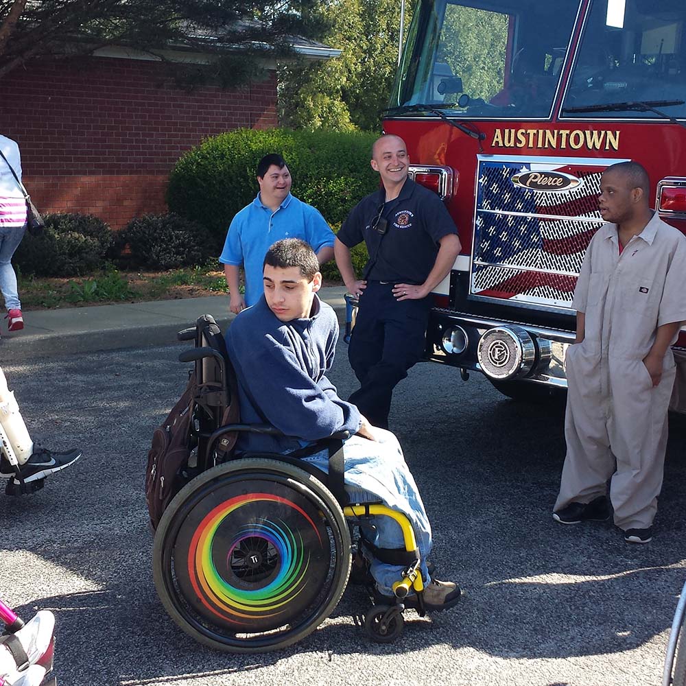Person in a wheelchair in front of a fire truck